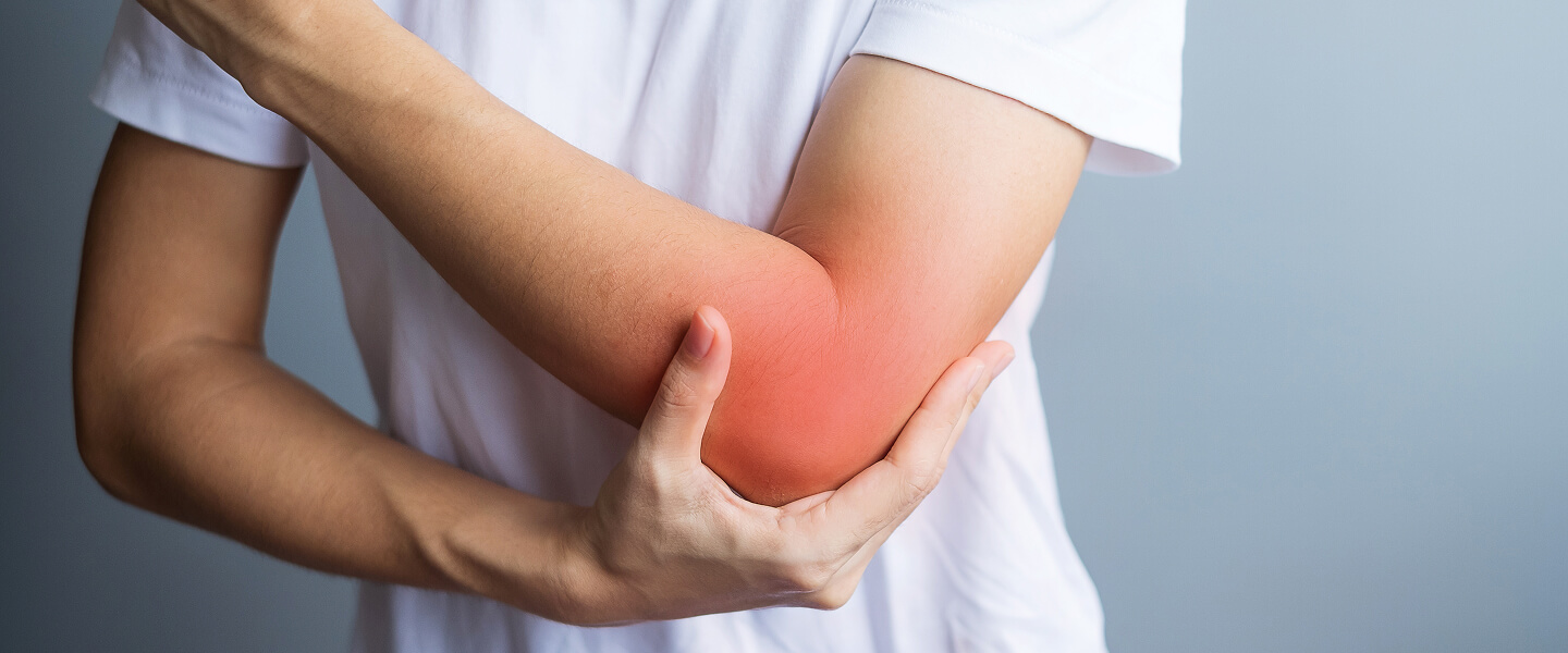 Close-up of a man holding his elbow in pain.
